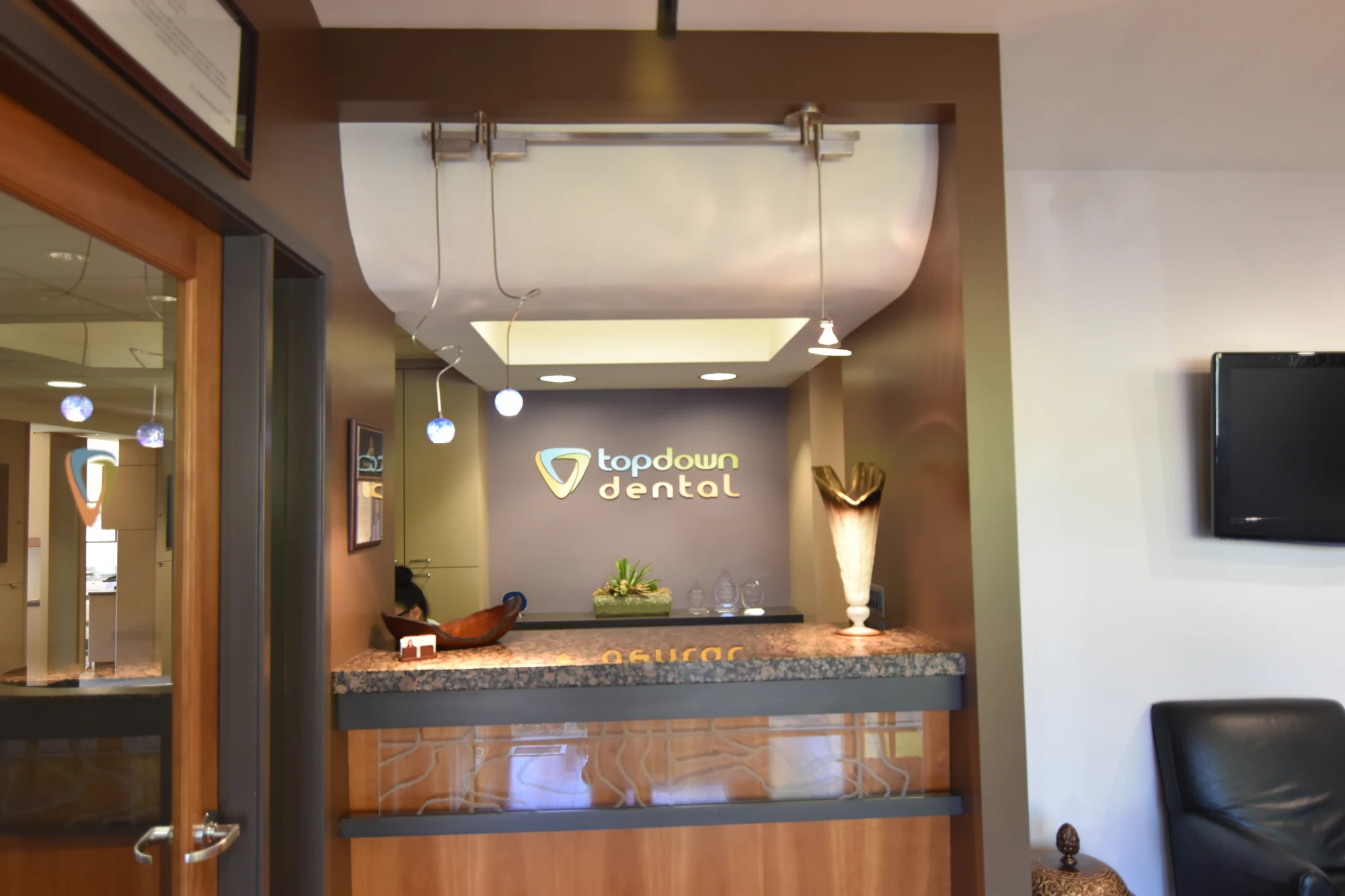 Top Down Dental front desk with the practice logo behind the reception counter